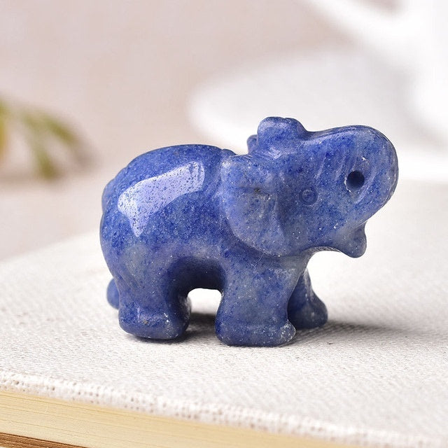 Sacred Moon Candle Co blue healing crystal elephant stone carved figurine on white surface